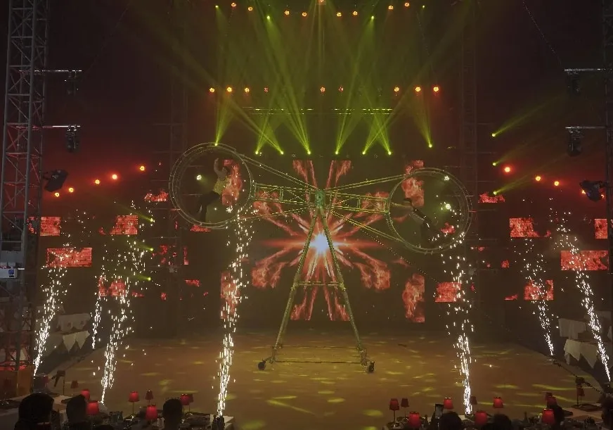 Performers on the wheel, surrounded by falling sparks
